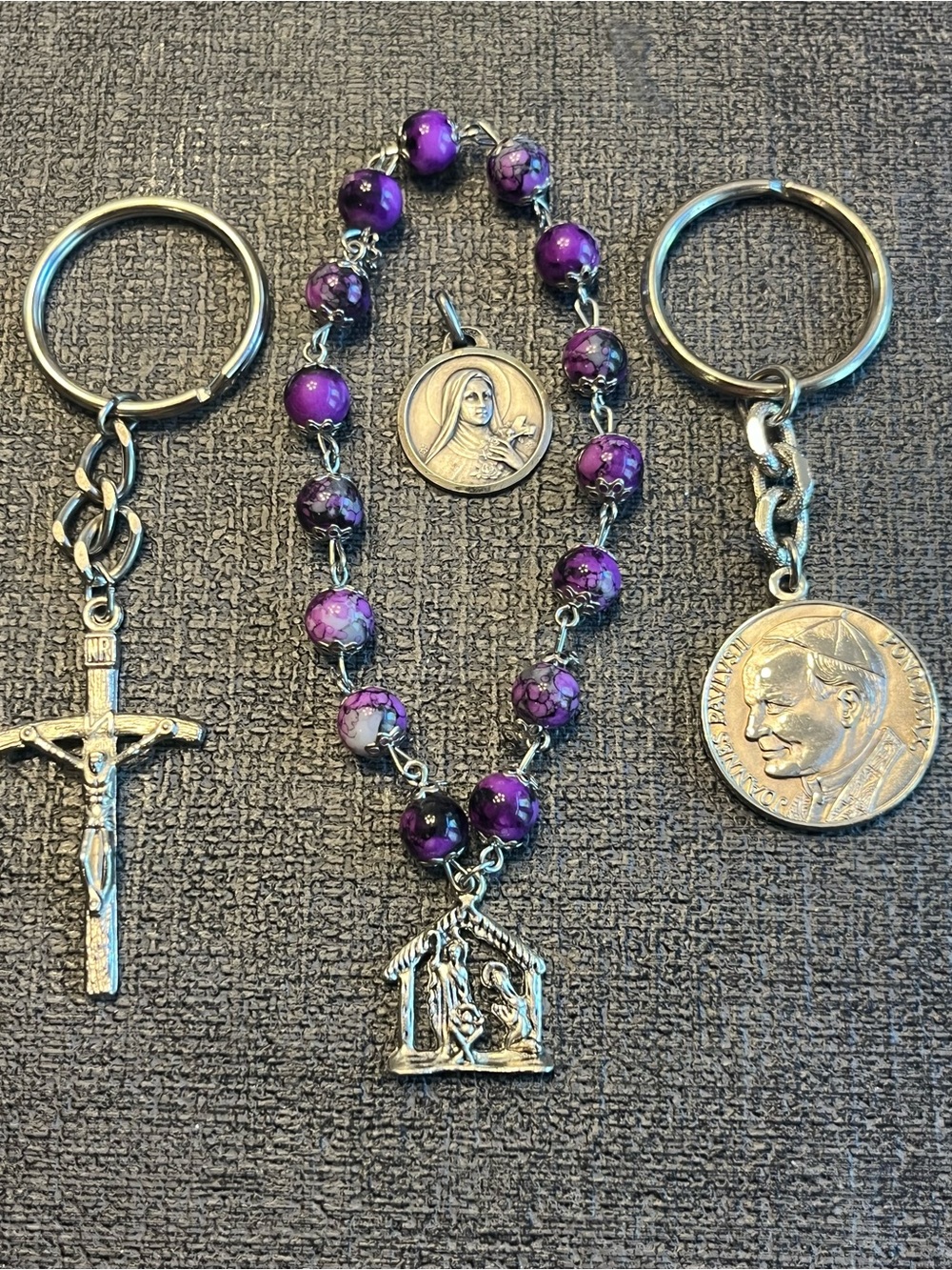 Two keychains and a rosary bracelet and a Mary pendant.